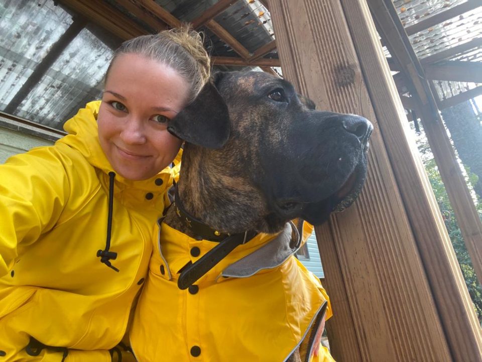 Tuuli Kotisalo ja koira puettuna keltaisiin sadeasuihin