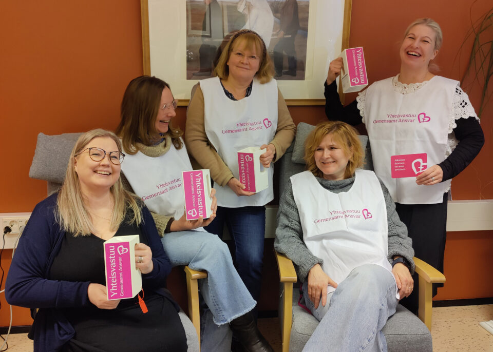 Työntekijöitä Yheisvastuun liivit päällään ja keräyslippaat kädessään.