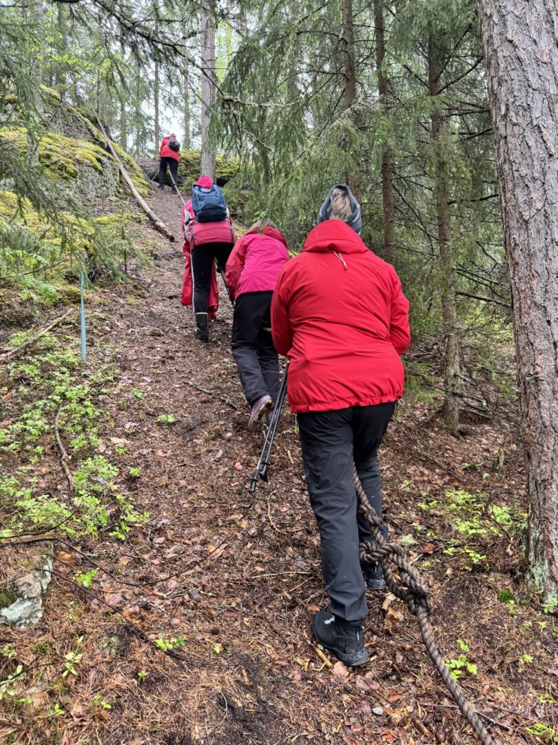 Ihmisiä kiipeämässä mäen rinnettä ylös.