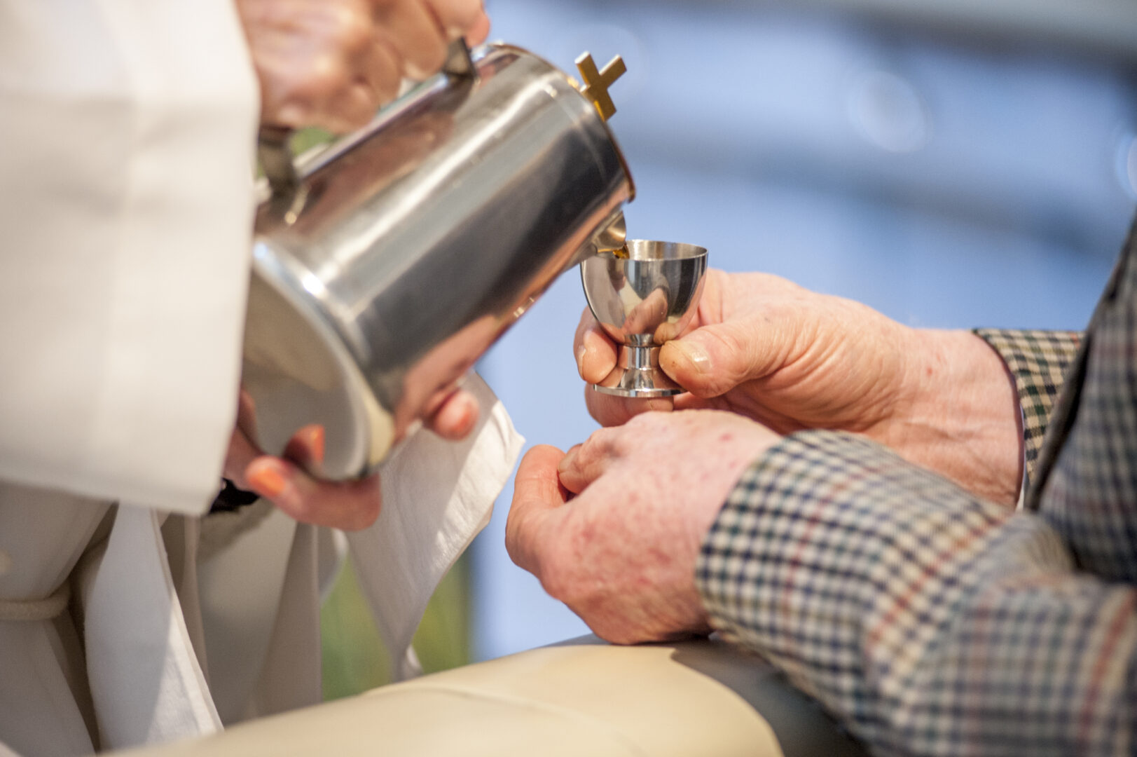 Ehtoollisviiniä kaadetaan pikariin.