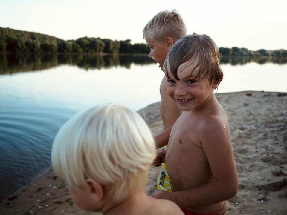 Kolme poikaa järven rannalla