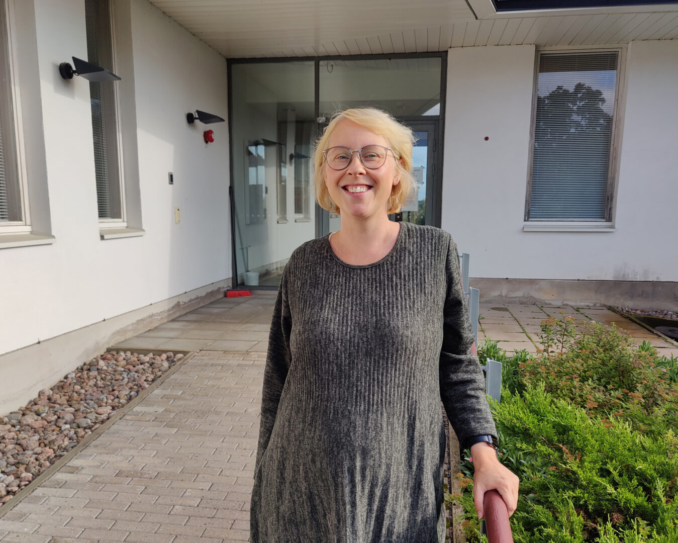 Kirkkoherra Anna Kinnunen nojaa Simeon-talon kaiteeseen.