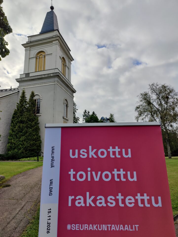 Marian kirkon edustalla seurakuntavaalien roll up tekstillä uskottu, toivottu, rakastettu.