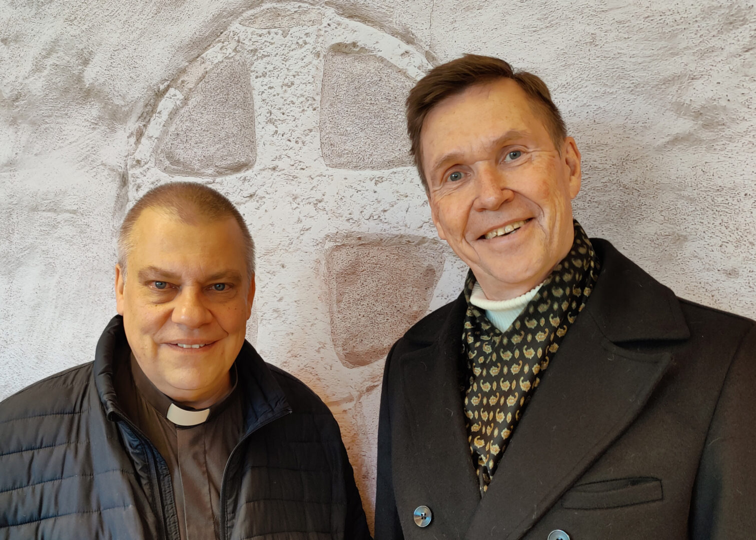 Pastorit Matti Astola ja Kari Rautiainen Marian kirkon vihkiristiä kuvaavan taulun edessä.